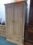 A MODERN OAK WARDROBE WITH THE TWO DOORS OVER TWO SHORT DRAWERS. W 107 x D 63 x H 195cms.