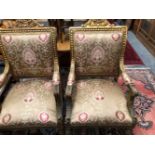 A PAIR OF GILT WOOD ELBOW CHAIRS, THE BACKS UPHOLSTERED WITHIN WAVY BANDS, THE ARM FRONTS CARVED