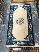 A GOOD QUALITY CHINESE SMALL RUG TOGETHER WITH A ORIENTAL RUG CAUCAUSIAN DESIGN.