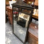 A VICTORIAN RECTANGULAR MIRROR WITHIN AN EBONISED FRAME, THE INCISED FOLIAGE AND ROUNDELS ON THE