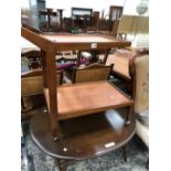 AN ERCOL OVAL COFFEE TABLE TOGETHER WITH A TWO TIER TROLLEY