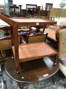 AN ERCOL OVAL COFFEE TABLE TOGETHER WITH A TWO TIER TROLLEY