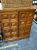 A MODERN OAK TWO DOOR DRINKS CABINET, THE CENTRALLY HINGED TOP OPENING TO REVEAL GREEN STONE INSETS,
