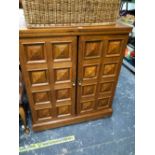 A MODERN OAK TWO DOOR DRINKS CABINET, THE CENTRALLY HINGED TOP OPENING TO REVEAL GREEN STONE INSETS,