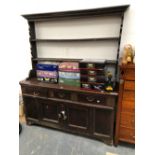 A 19th C. OAK DRESSER WITH AN OPEN TWO SHELF BACK ABOVE THREE DRAWERS AND A PAIR OF PANELLED