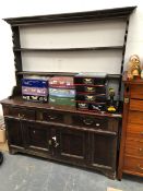 A 19th C. OAK DRESSER WITH AN OPEN TWO SHELF BACK ABOVE THREE DRAWERS AND A PAIR OF PANELLED