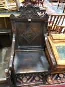 A 17th C. AND LATER OAK WAINSCOT CHAIR, THE TOP RAIL CARVED WITH THREE FLORAL ROUNDELS ANOTHER