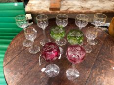 A COLLECTION OF LONG STEM GLASSES, SOME BURGUNDY AND GREEN TINTED