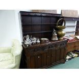 A 20th C. OAK DRESSER, THE ENCLOSED THREE SHELF BACK ABOVE A BASE WITH THREE FOLIATE CARVED