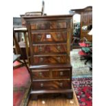 A MODERN MAHOGANY MINIATURE CHEST ON CHEST WITH A CONFIGURATION OF EIGHGT DRAWERS ON BRACKET FEET. W