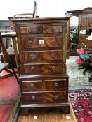 A MODERN MAHOGANY MINIATURE CHEST ON CHEST WITH A CONFIGURATION OF EIGHGT DRAWERS ON BRACKET FEET. W
