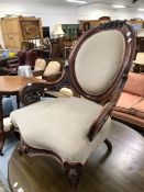 A VICTORIAN MAHOGANY SHOW FRAME ARMCHAIR, THE OVAL BACK CRESTED BY FLOWERS, THE ARMS PIERCED AND