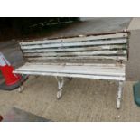 AN ANTIQUE PAINTED GARDEN BENCH WITH CAST IRON SUPPORTS AND UNUSUAL FOLDING BACK REST