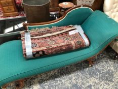 A VICTORIAN MAHOGANY SHOW FRAME CHAISE LONGUE UPHOLSTERED IN GREEN, THE CARVED LEGS SWEEPING DOWN TO