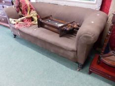 A BROWN UPHOLSTERED CHESTERFIELD ON TURNED MAHOGANY LEGS WITH CERAMIC CASTER FEET. W 190 x D 77 x