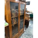 A 20th C. OAK DISPLAY CABINET, THE GLAZED DOORS BETWEEN FLUTED PILASTERS AND ENCLOSING FOUR