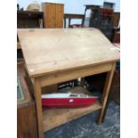 A PINE CLERKS DESK, THE SLOPING FALL ENCLOSING A COMARTMENT ABOVE A SHELF BETWEEN THE SQUARE LEGS. W