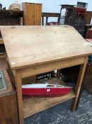 A PINE CLERKS DESK, THE SLOPING FALL ENCLOSING A COMARTMENT ABOVE A SHELF BETWEEN THE SQUARE LEGS. W