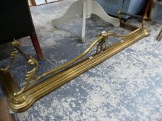 A VICTORIAN BRASS FIRE KERB WITH TUBULAR IRON FIRE IRON RESTS AT EACH END. W 140cms. AND TWO OTHERS