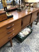 AN AVALON TEAK SIDEBOARD WITH THREE DRAWERS FLANKING A CUPBOARD WITH TWO SLIDING DOORS ABOVE