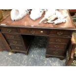 A 20th C. MAHOGANY PEDESTAL DESK, THE RED LEATHER INSET TOP ABOVE A KNEEHOLE DRAWER FLANKED BY BANKS