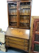 A 20th C. MAHOGANY BUREAU BOOK CASE, THE UPPER HALF GLAZED, THE FALL ABOVE THREE GRADED DRAWERS