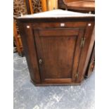 A GEORGE III OAK CORNER CUPBOARD WITH A PANELLED DOOR. W 89 x H 99cms.