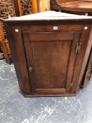 A GEORGE III OAK CORNER CUPBOARD WITH A PANELLED DOOR. W 89 x H 99cms.