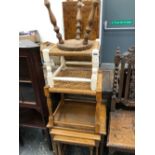 A 20th C. NEST OF THREE OAK TABLES, TWO RUSH SEATED STOOLS AND ANOTHER STOOL WITH A PINE CIRCULAR