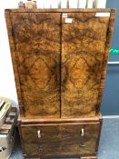 AN ART DECO BURR WALNUT CABINET, THE TWO DOORS OF THE TOP ENCLOSING SHELVES ABOVE TWO DRAWERS AND