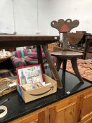 A RUSTIC OAK FOUR LEGGED STOOL TOGETHER WITH AN OAK TRIPOD CHAIR, THE BACK FORMED OF TWO HEARTS ON A