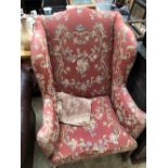 A WING ARMCHAIR UPHOLSTERED ON TERRACOTTA GROUND FLORAL DAMASK, THE CHANNELLED SQUARE FRONT LEGS