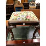 AN 18th C. WALNUT STOOL, THE FLORAL NEEDLEWORK DROP IN SEAT ABOVE SHELL CARVED CABRIOLE LEGS ON