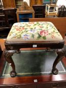 AN 18th C. WALNUT STOOL, THE FLORAL NEEDLEWORK DROP IN SEAT ABOVE SHELL CARVED CABRIOLE LEGS ON