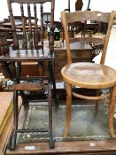 A CHILDS FOLDING HIGH CHAIR SUPPORTED ON IRON SPOKED WHEELS TOGETHER WITH A THONET TYPE SIDE CHAIR