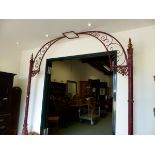 A RED PAINTED IRON ARCH CRESTED BY A LANTERN RECEIVER, THE SIDE POLES WITH GILT DETAILS AND AN