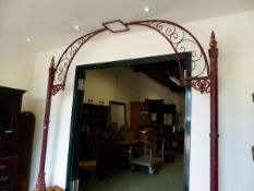 A RED PAINTED IRON ARCH CRESTED BY A LANTERN RECEIVER, THE SIDE POLES WITH GILT DETAILS AND AN