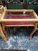 AN EARLY 20th C. BIRDS EYE MAPLE DISPLAY TABLE, THE RECTANGULAR LID WITH AN ORMOLU EDGE, THE