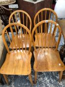 A SET OF FOUR KITCHEN CHAIRS WITH STICK HOOP BACKS, OAK SADDLE SEATS AND SPINDLE TURNED LEGS