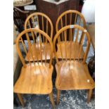 A SET OF FOUR KITCHEN CHAIRS WITH STICK HOOP BACKS, OAK SADDLE SEATS AND SPINDLE TURNED LEGS