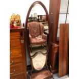 A 20th C. OVAL FULL LENGTH MIRROR IN A MAHOGANY CHEVAL FRAME TOGETHER WITH A GEORGE III SHIELD