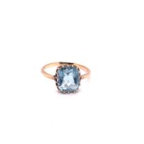 AN ANTIQUE AQUAMARINE RING IN A MULTI CLAW SETTING. UNHALLMARKED, ASSESSED AS 9ct GOLD. FINGER