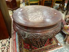 AN ORIENTAL CARVED HARDWOOD CENTRE TABLE. H 75 X DIAMETER 106cms.