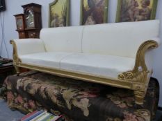 A WILLIAM IV GILT WOOD SETTEE UPHOLSTERED IN CREAM DAMASK, THE ARM FRONTS SCROLLING DOWN TO FOLIAGE