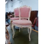 A PAIR OF ROCOCO TASTE PINK DETAILED CREAM PAINTED CHAIRS, THE UPHOLSTERED BACKS CRESTED BY