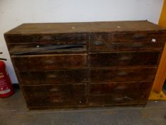 A VICTORIAN PINE CHEST OF THIRTEEN DRAWERS EACH WITH IRON CUP HANDLES AND ARRANGED PRIMARILY IN