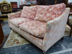 A HOWARD SETTEE WITH UPHOLSTERED RECTANGULAR BACK AND SLOPING ARMS, THE SQUARE MAHOGANY LEGS