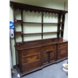 A 19th C. OAK DRESSER, THE THREE OPEN BACKED SHELVES TO THE BACK FLANKED BY THREE SMALLER SHELVES