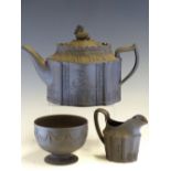 A 19th C. BLACK BASALT TEA POT, A MILK JUG AND A FOOTED BOWL WITH VARIOUS CLASSICAL MOULDINGS, THE
