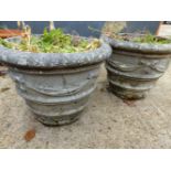 A PAIR OF WEATHERED RECONSTITUTED STONE GARDEN URNS